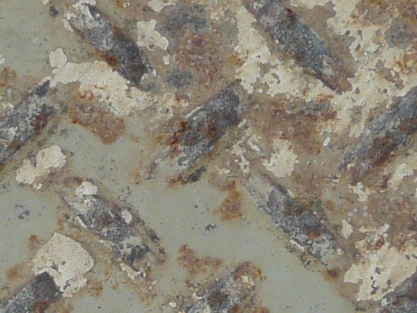 Old metal tread texture with repeating pattern and very worn surface.